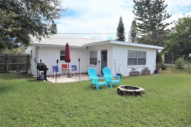a view of a backyard with table and chairs and a fire pit