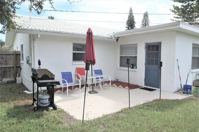 a view of a house with backyard and sitting area