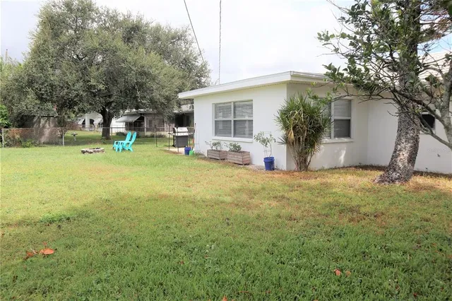 a view of a house with backyard and chairs