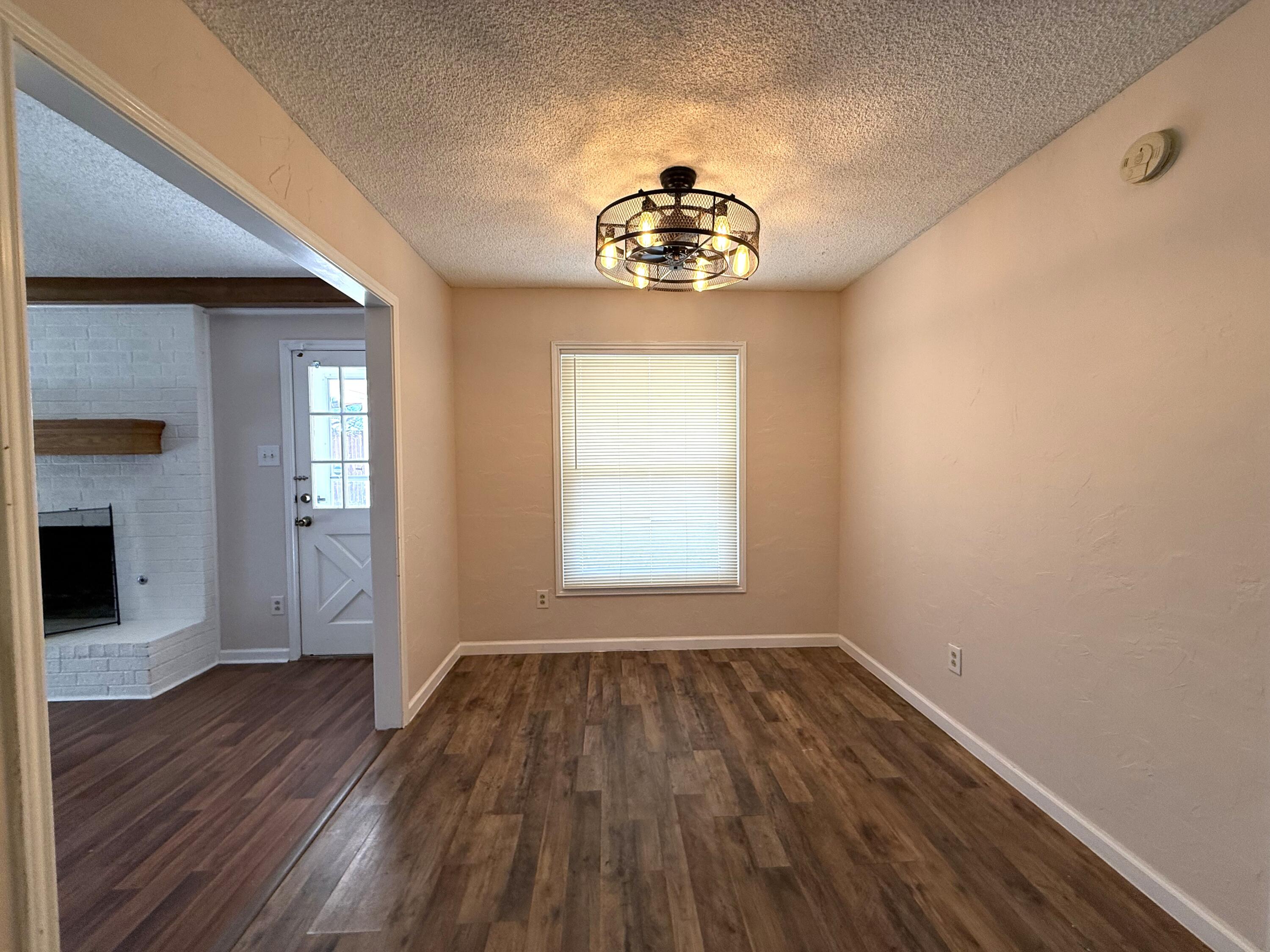 5729 89th Street Lubbock, TX 79424 - Photo 6 of 15 wooden floor in an empty room with a window