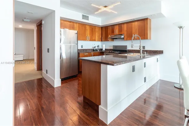 a kitchen with stainless steel appliances granite countertop a sink stove and refrigerator