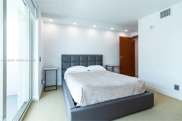 a bedroom with a large bed and a window