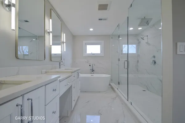 a spacious bathroom with a shower sink double vanity and mirror