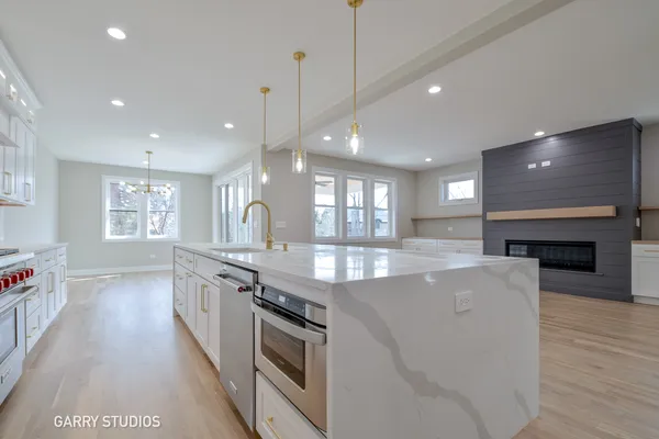 a large kitchen with granite countertop a stove and a wooden floors