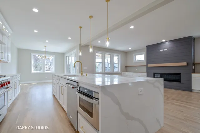 a large kitchen with granite countertop a stove and a wooden floors