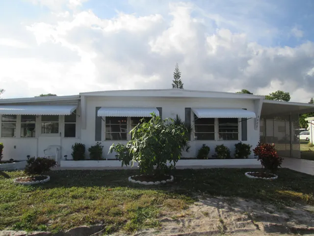 a view of a house with backyard sitting area and garden