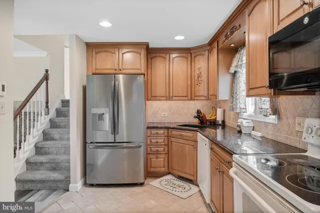 a kitchen with granite countertop white cabinets and stainless steel appliances