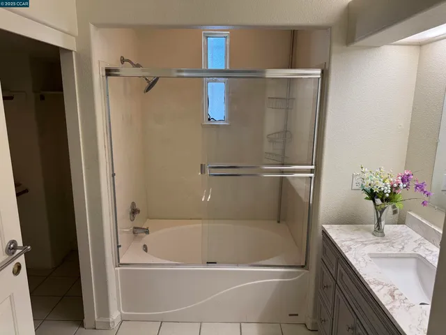 a bathroom with a granite countertop sink mirror and a bathtub