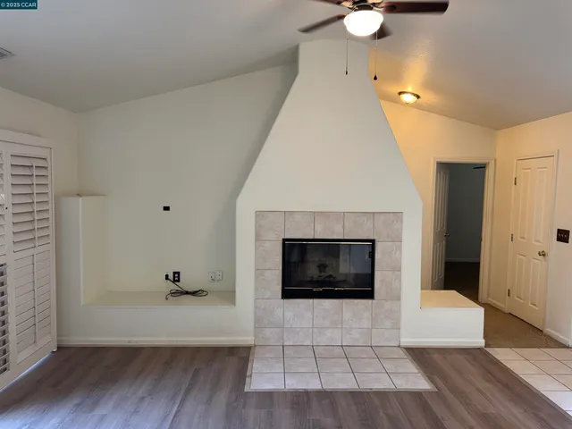an empty room with wooden floor and fireplace