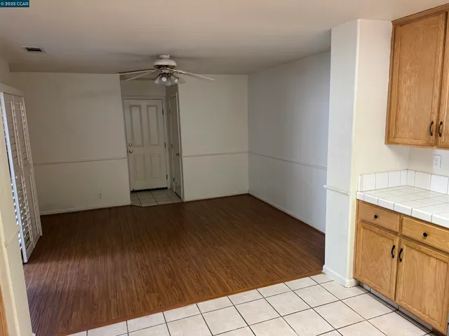 an empty room with wooden floor and cabinet