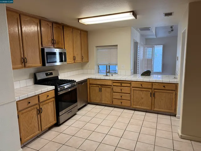 a kitchen with stainless steel appliances a sink stove top oven and cabinets