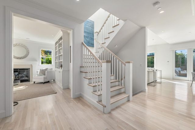 a view of a livingroom with wooden floor stairs and a fireplace