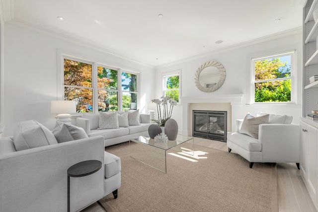 a living room with furniture a fireplace and a large window