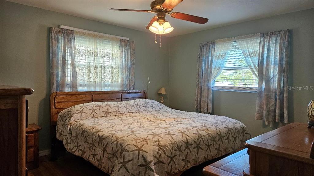 4600 98th Way North, Unit 210 St. Petersburg, FL 33708 - Photo 13 of 33 a bed sitting in a bedroom next to a window