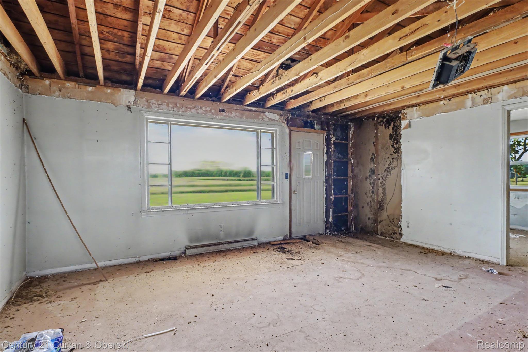 7504 Meisner Road Casco, MI 48064 - Photo 5 of 27 Exposed ceiling joists with visible wood planking, multi-pane window, and a paneled entry door