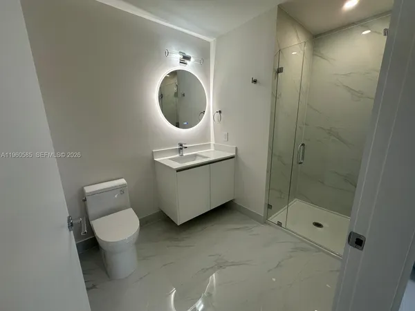 a bathroom with a granite countertop sink a toilet and shower