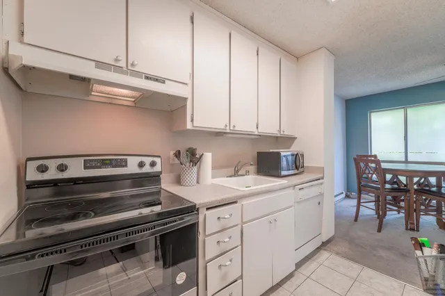 a kitchen with a refrigerator a sink and a stove top oven