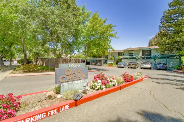 a view of road with a building and trees in the background