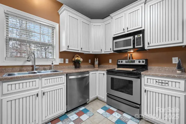 a kitchen with stainless steel appliances granite countertop a stove a sink and a microwave