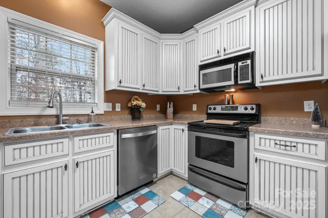 a kitchen with stainless steel appliances granite countertop a stove a sink and a microwave