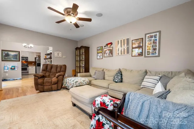 a living room with furniture ceiling fan and a rug