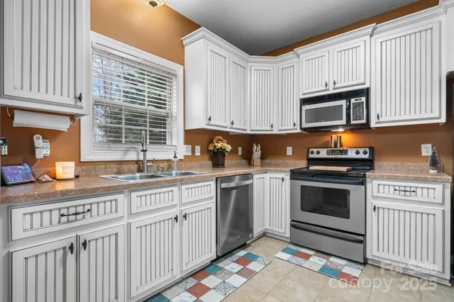 a kitchen with granite countertop a sink stove and cabinets
