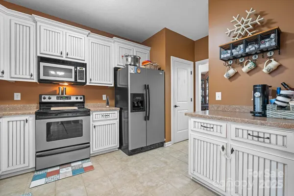 a kitchen with stainless steel appliances white cabinets a stove a sink and a refrigerator