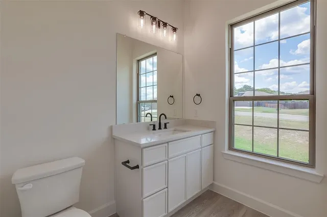 a bathroom with a sink a toilet and a window