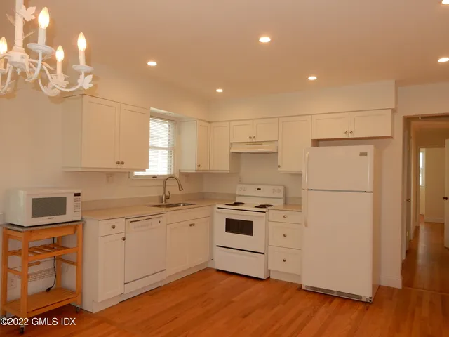 a kitchen with white cabinets and white appliances