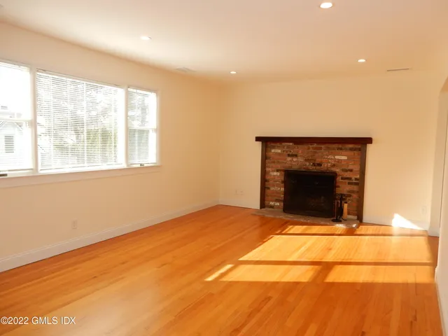 a view of an empty room with a fireplace and a window