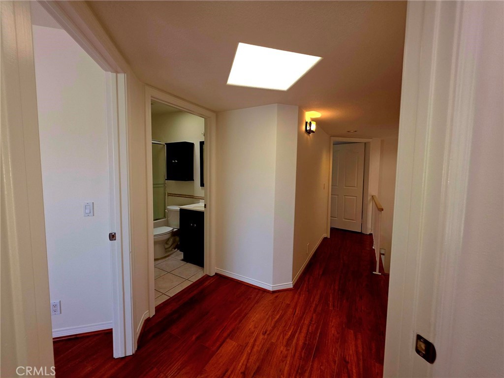 5340 Las Virgenes Road, Unit 1 Calabasas, CA 91302 - Photo 19 of 23 a view of a hallway with wooden floor and a bathroom