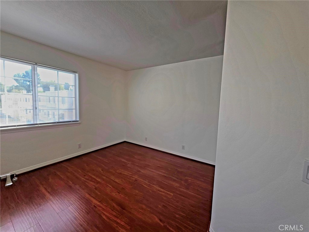 5340 Las Virgenes Road, Unit 1 Calabasas, CA 91302 - Photo 21 of 23 an empty room with wooden floor and windows