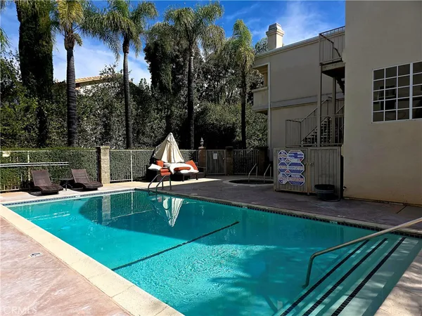 a view of a swimming pool with a bench and trees