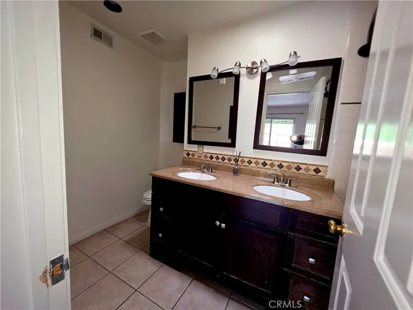 a bathroom with a double vanity sink and mirror