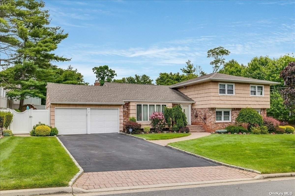 2 Pound Ridge Road Plainview, NY 11803 - Photo 1 of 1 a front view of a house with a garden and plants