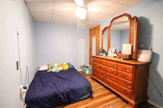 a bedroom with a bed and a mirror on the dresser