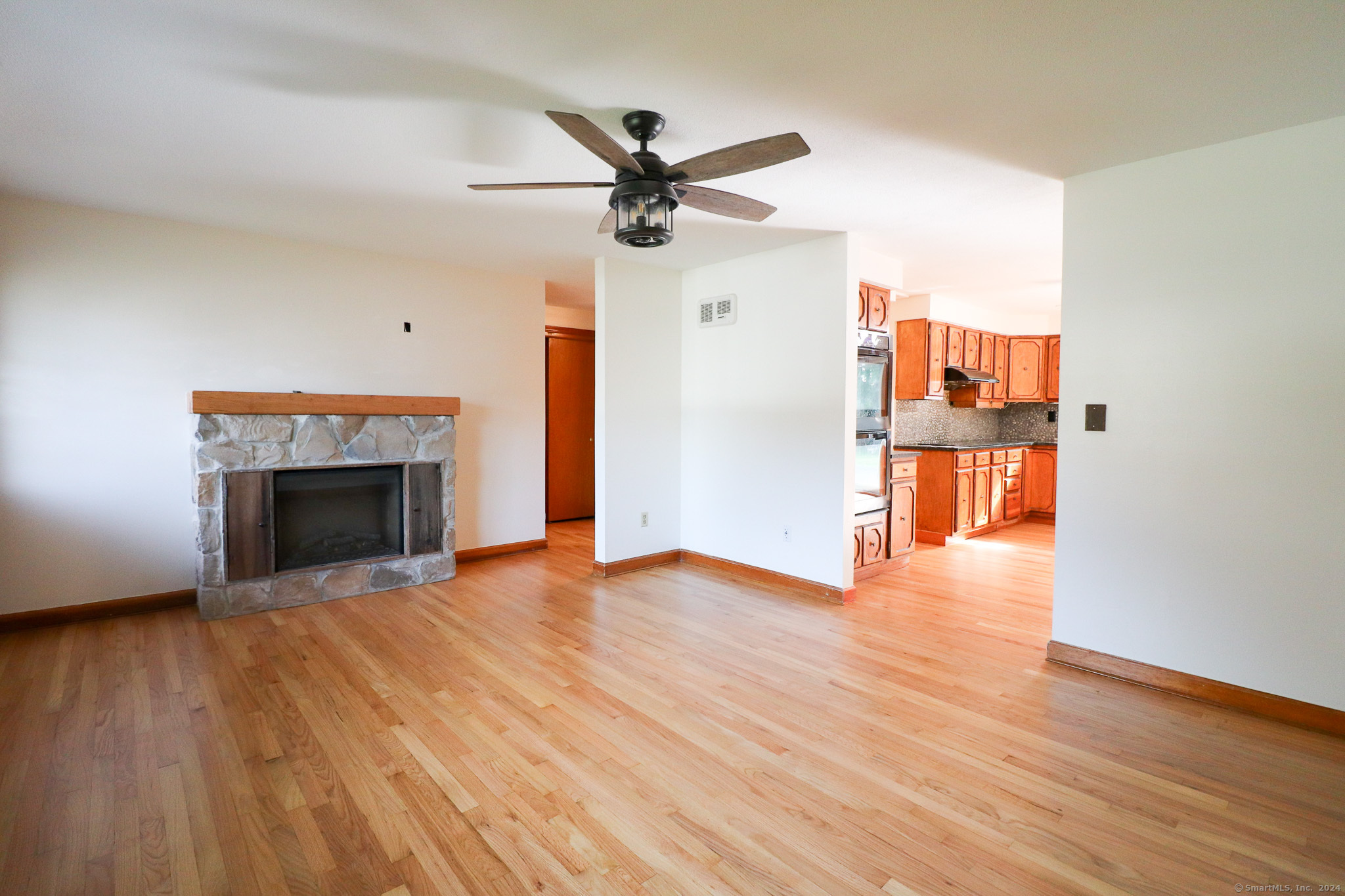 63 Home Avenue Meriden, CT 06451 - Photo 5 of 26 a view of empty room with wooden floor fireplace and a window