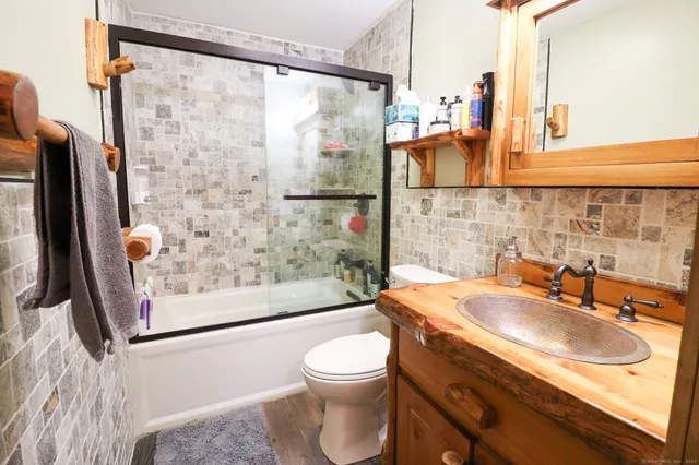 a bathroom with a sink a toilet and shower
