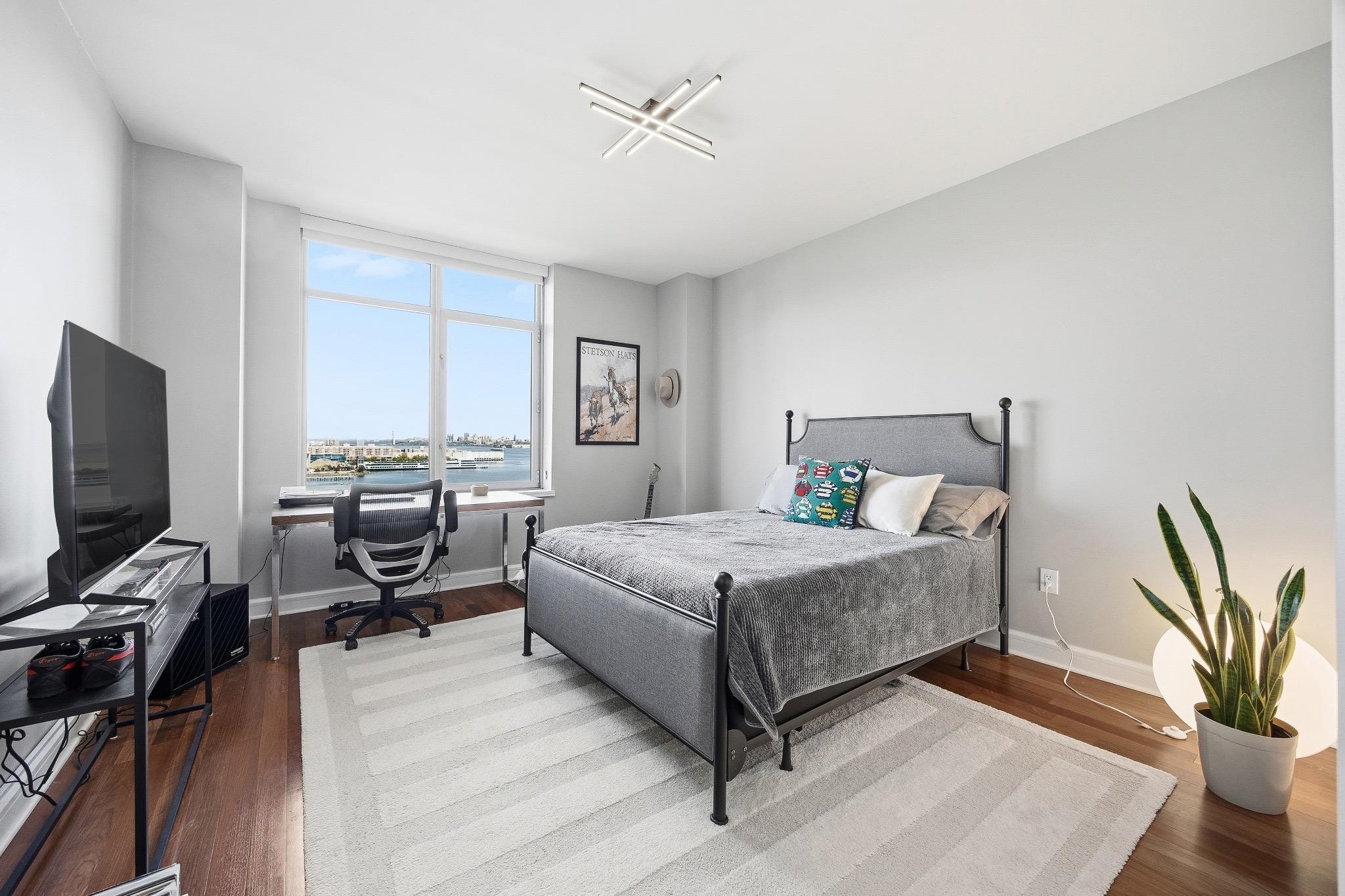 8100 River Road, Unit 1203 North Bergen, NJ 07047 - Photo 13 of 31 a bedroom with a bed and a flat screen tv