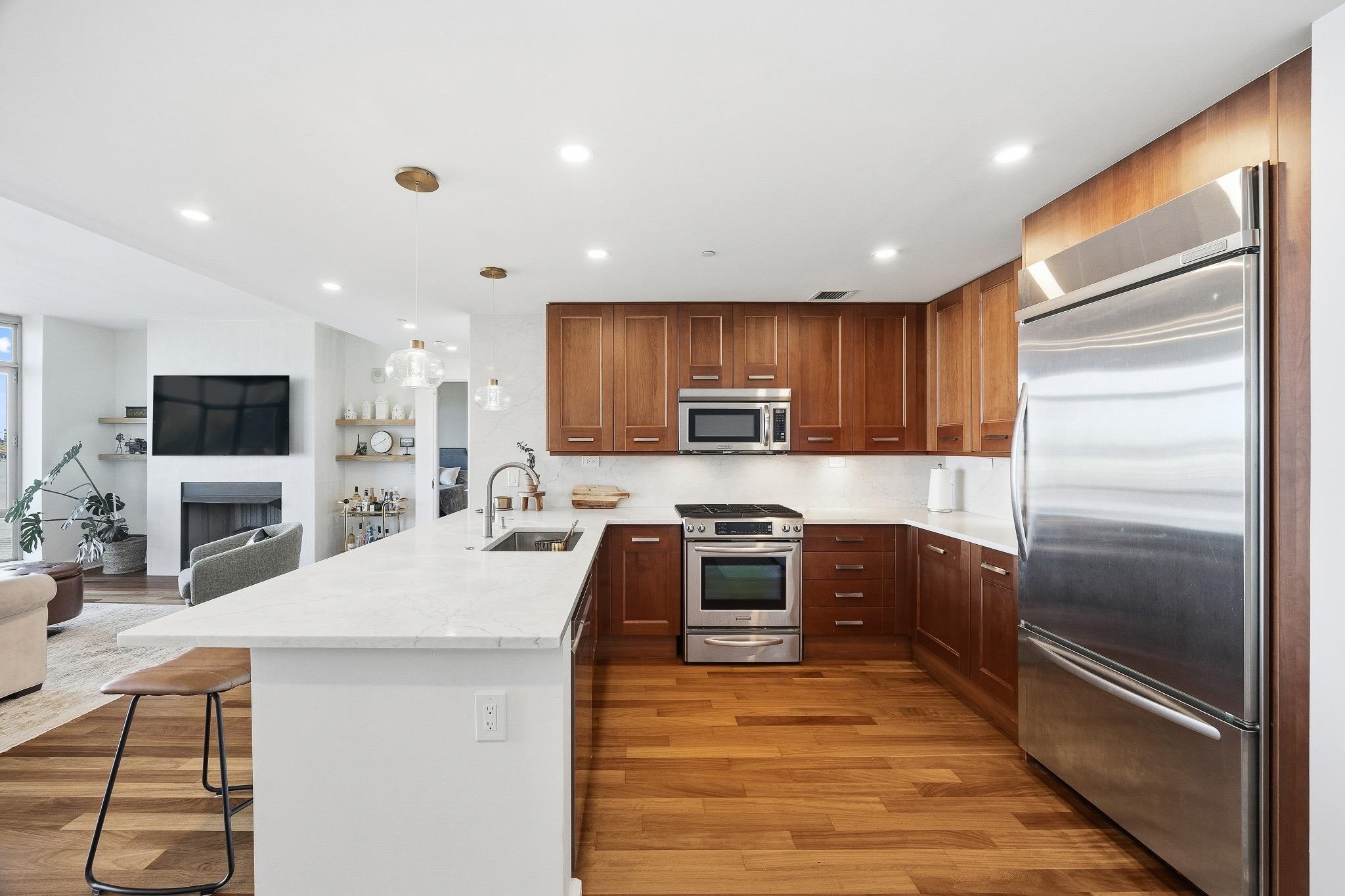 8100 River Road, Unit 1203 North Bergen, NJ 07047 - Photo 7 of 31 a kitchen with granite countertop a refrigerator stove top oven and kitchen island