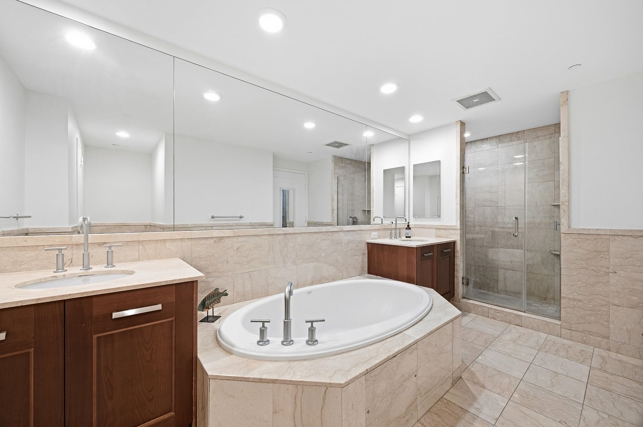 8100 River Road, Unit 1203 North Bergen, NJ 07047 - Photo 9 of 31 a bathroom with a bathtub shower sink and mirror