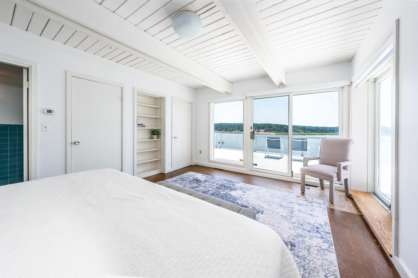 945 Chequessett Neck Road Wellfleet, MA 02667 - Photo 24 of 57 a spacious bedroom with a large bed and a large window