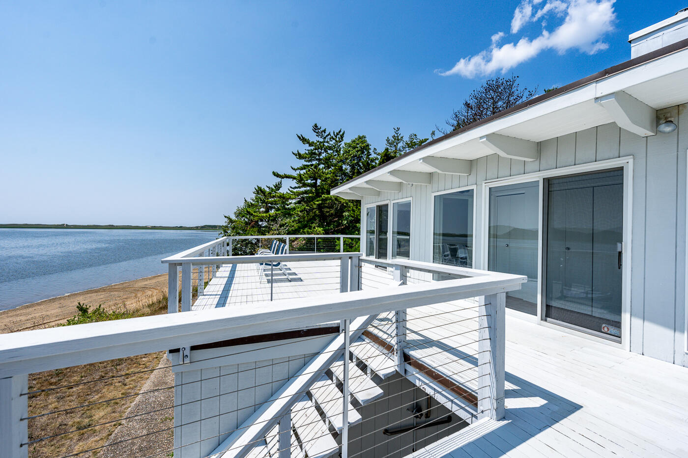 945 Chequessett Neck Road Wellfleet, MA 02667 - Photo 50 of 57 a view of a patio with table and chairs with wooden floor and fence