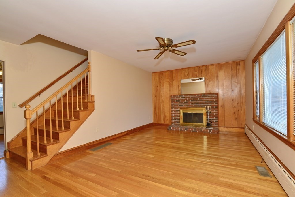 44 Everett Street Franklin, MA 02038 - Photo 14 of 31 a view of a livingroom with wooden floor a fireplace and windows