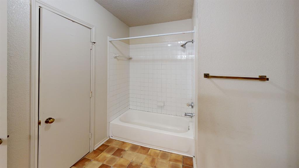 853 West Wintergreen Road Lancaster, TX 75134 - Photo 16 of 20 White shower-over-tub combination with subway tile surround and a bronze towel bar