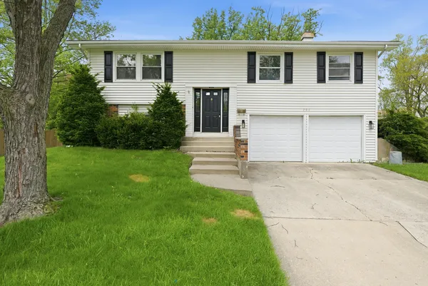 a front view of a house with a garden