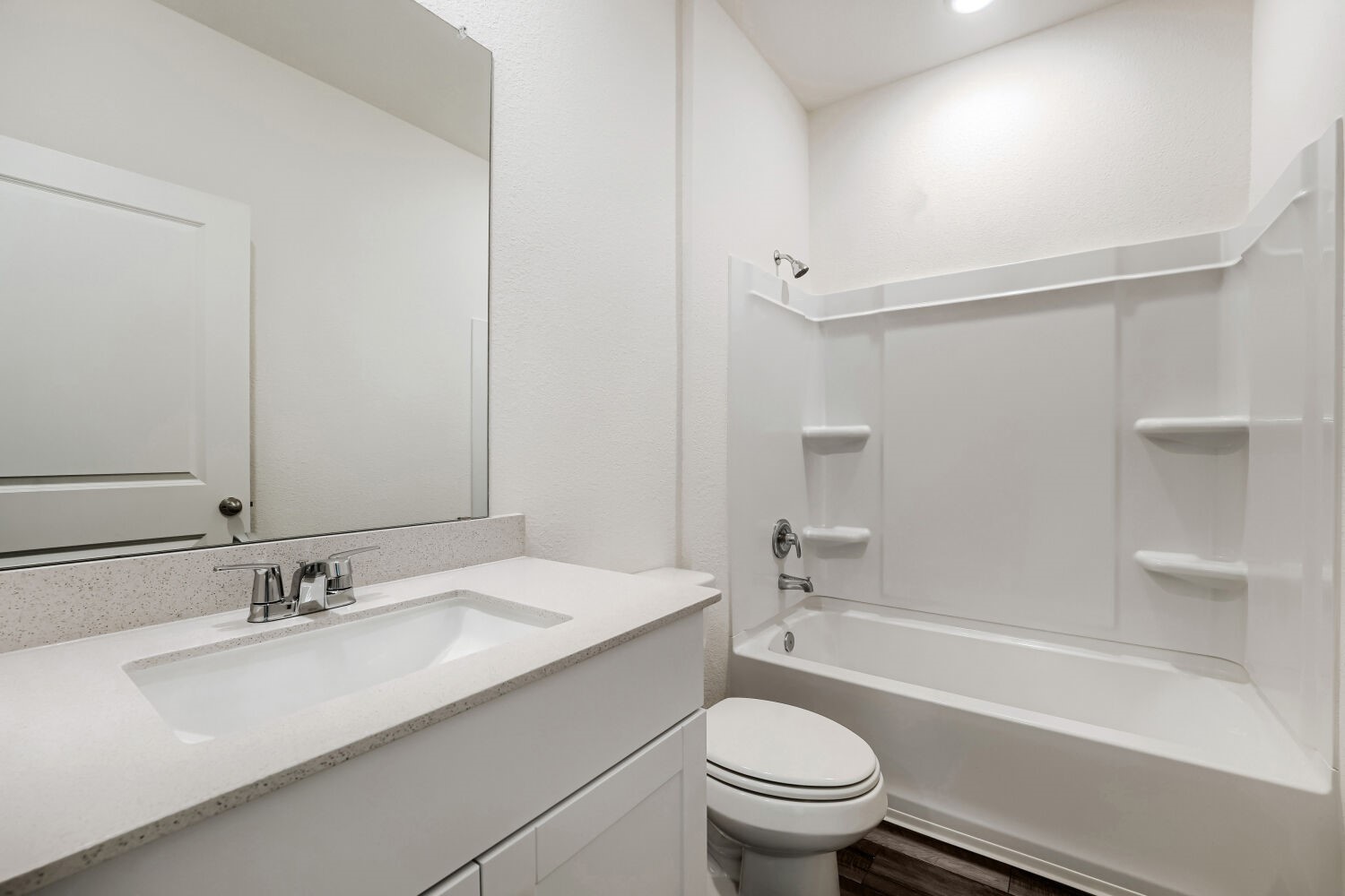 124 Mullen Way Taylor, TX 76574 - Photo 16 of 22 Bathroom featuring a white vanity with an undermount sink, a speckled countertop, and a chrome faucet