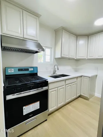 a kitchen with granite countertop white cabinets and stainless steel appliances