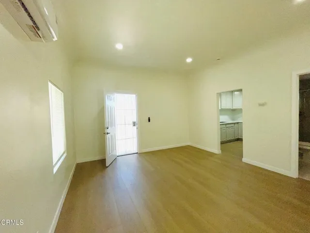 a view of empty room with wooden floor and windows