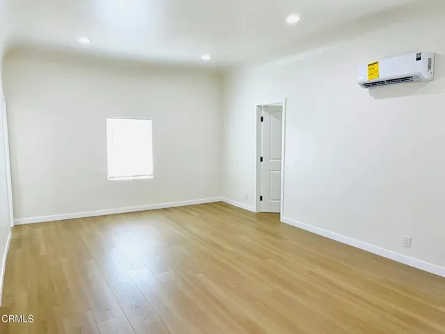 an empty room with wooden floor and a window